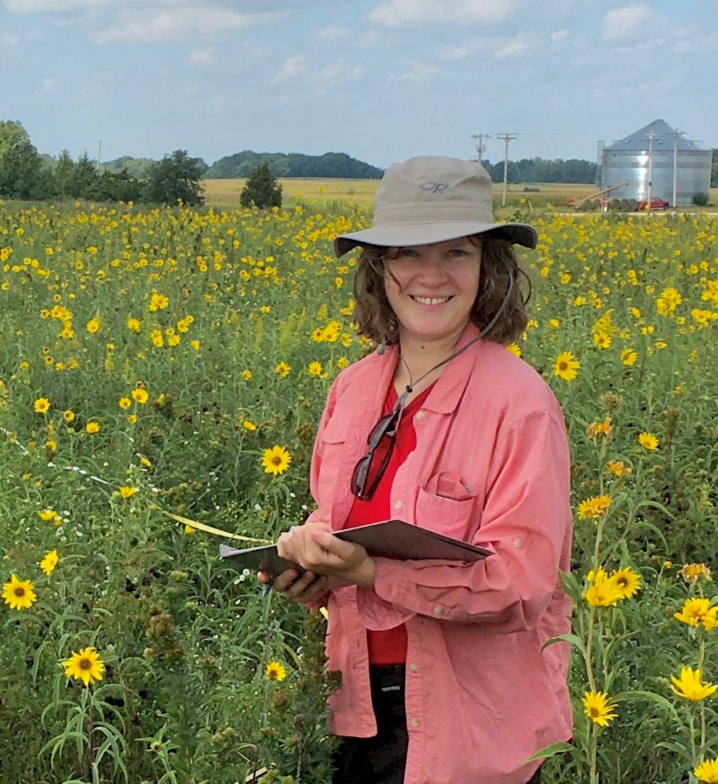 Young woman holding a clipboard in a field